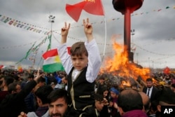 People are seen gathered around a bonfire after Turkish authorities permitted a Newroz celebration, in predominantly Kurdish Diyarbakir, Turkey, March 21, 2017. The successes of Syrian Kurdish forces have become a powerful symbol for Kurds in Turkey.