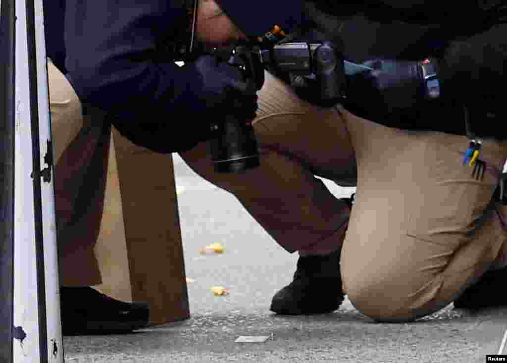 A member of the NYPD Crime Scene Unit takes a picture of a shell casing found at the scene where the CEO of UnitedHealthcare Brian Thompson was reportedly shot and killed in Midtown Manhattan, in New York City.