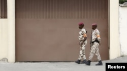 Soldiers walk in front of the headquarters of Constitutional Council before the proclamation of the final list of candidates for the presidential election in Abidjan, Ivory Coast, Sept. 9, 2015.