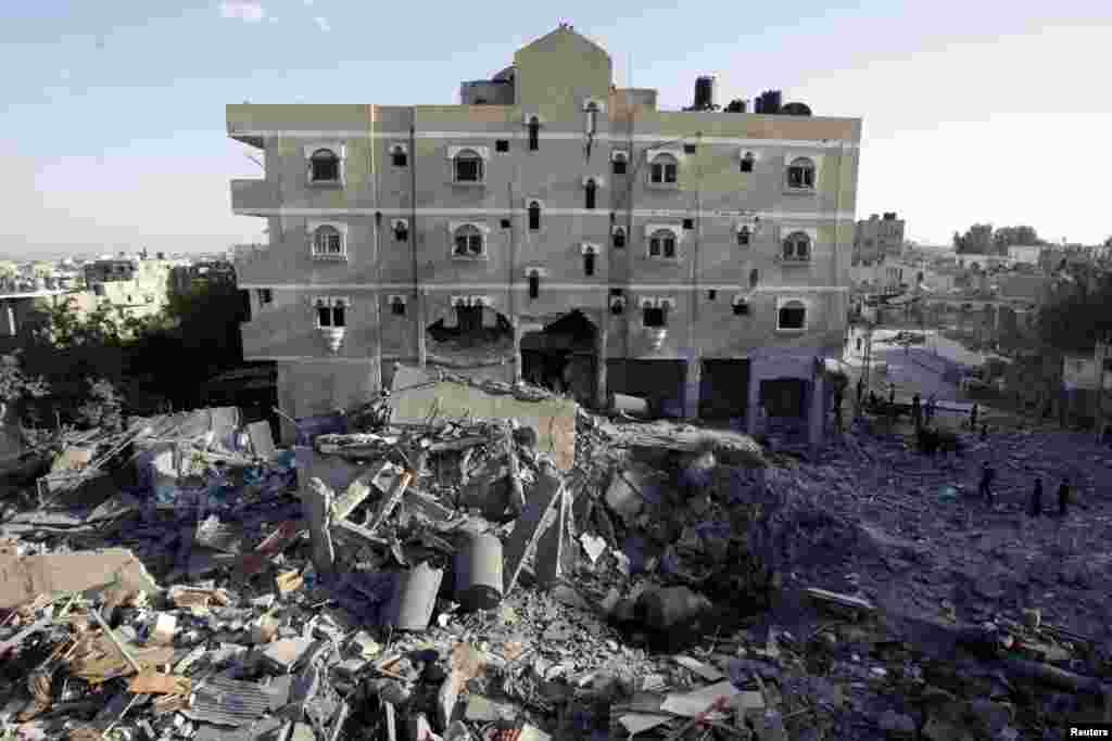 Palestinci pregledavaju uništenu kuću nakon izraelskog zračnog udara na Rafu, na jugu Pojasa Gaze, 18. novembra 2012.