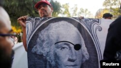 A union worker holds a banner during a protest against NAFTA negotiations outside where the fifth round of NAFTA talks involving the United States, Mexico and Canada in Mexico City, Mexico, Nov. 17, 2017.