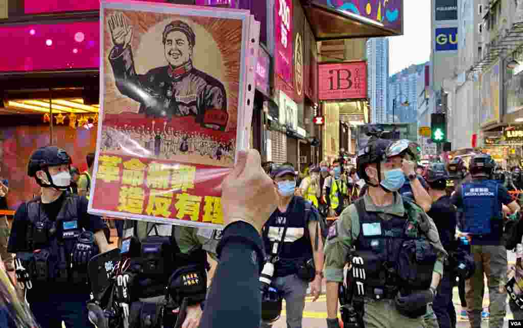 有香港市民10月1日下午在銅鑼灣崇光百貨附近，對著警方封鎖線高舉文化大革命標語。(美國之音湯惠芸) 