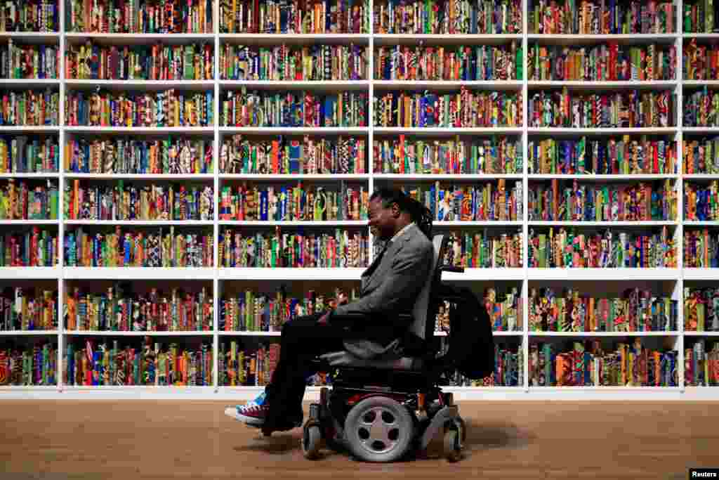 British-born Nigerian artist Yinka Shonibare stands with his art piece, called "The British Library," at Tate Modern in London, April 8, 2019.