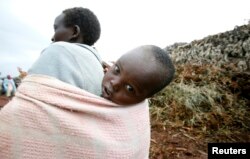 A woman, evicted from the forest, carries her son in Kapkembu near the Mau Forest, Nov.18, 2009.
