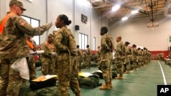 FILE - In this image from the U.S. Army, recent basic combat training graduates have their temperatures taken at Fort Lee, Va., March 31, 2020, after being transported using sterilized buses from Fort Jackson, S.C. COVID-19 has had a dramatic impact on military recruiting.