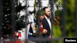 FILE - An unidentified soldier accused of attempting to assassinate Turkish President Tayyip Erdogan on the night of last year's July 15 failed coup, is escorted by gendarmes as he leaves the final hearing of the trial in Mugla, Turkey, Oct. 4, 2017.