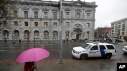 FILE - A woman walks past the 9th U.S. Circuit Court of Appeals building.