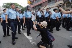 FILE - A supporter begs police not to attack protesters in Hong Kong, July 31, 2019.