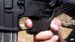 FILE - Shooting instructor Frankie McRae demonstrates the grip on an AR-15 rifle fitted with a bump stock at his 37 PSR Gun Club in Bunnlevel, North Carolina, on Oct. 4, 2017.