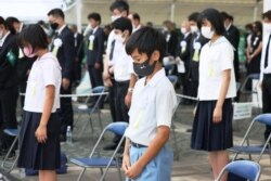 Warga menjaga jarak sosial saat mengheningkan cipta untuk menghormati para korban bom atom 1945 dalam upacara peringatan 76 tahun pengeboman di Nagasaki, di Taman Perdamaian Nagasaki di Nagasaki, Jepang, 9 Agustus 2021. (Kyodo/via REUTERS)