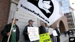 Winston Warfield of Boston, second from left, holds a placard while standing with other protesters outside federal court in Boston as they demonstrate against the death penalty in Boston Marathon bomber Dzhokhar Tsarnaev's trial, May 14, 2015. 