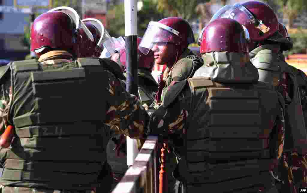 Kenyan policemen stand guard near the parliament building during the debate of controversial new security legislation, in Nairobi, Dec. 18, 2014.