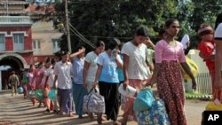 Prisoners walk out Myanmar's Insein Prison after they were released as the new government cut one year from their prison terms under a "general amnesty", May 17, 2011