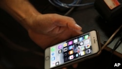 FILE: A man on his cell phone at an internet cafe in Tehran, Iran. Iranians must scroll through an array of icons on their smartphones, searching for the best workaround to bypass official censors. It’s a cat-and-mouse game that has become second nature. Taken July 25, 2019.