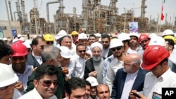 FILE - In this photo released by the office of the Iranian president on April 30, 2017, then-President Hassan Rouhani, center, inaugurates a new refinery in Bandar Abbas, Iran. Global oil prices might hinge on Israel's military response to Iran's Oct. 1, 2024, missile attacks.