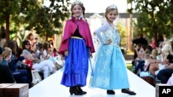 FILE - Child models are seen dressed up as Anna (L) and Elsa (R) from Disney's "Frozen" movie at a Halloween fashion show.