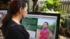 A woman reads a biography of LGBTIQ community members, displayed at a photo exhibition during a report launch at the Cambodian Center for Human Rights, Phnom Penh, on Dec. 9, 2019. (Kann Vicheika/VOA Khmer) 