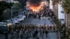 Tires burn as supporters of Lebanese Shiite Islamist movement Hezbollah stand before Lebanese Army soldiers during a Hezbollah-organized rally to block the road to Beirut International Airport over a decision to bar two Iranian flights from landing there, Feb. 15, 2025.