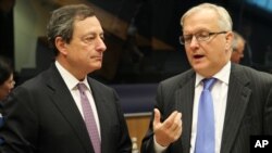 President of the European Central Bank Mario Draghi, left, listens to European Commissioner for Economic and Monetary Affairs Olli Rehn, during the Eurogroup meeting, in Luxembourg, October 8, 2012.