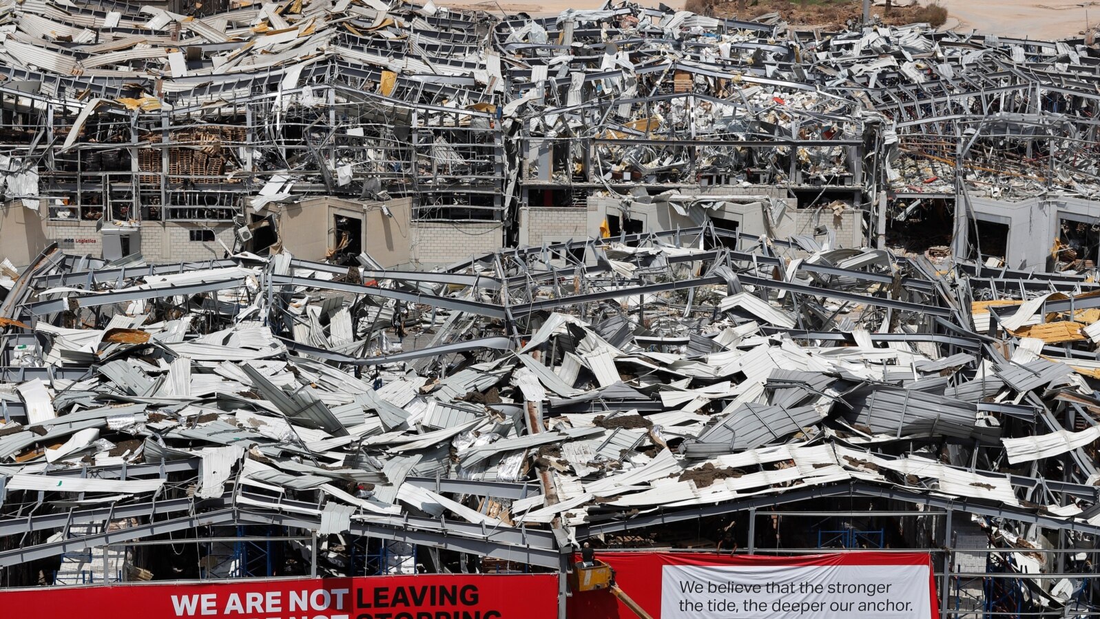 A worker sets banners at the port warehouses that were destroyed by Aug. 4 explosion that hit the seaport of Beirut, Lebanon, Aug. 19, 2020.