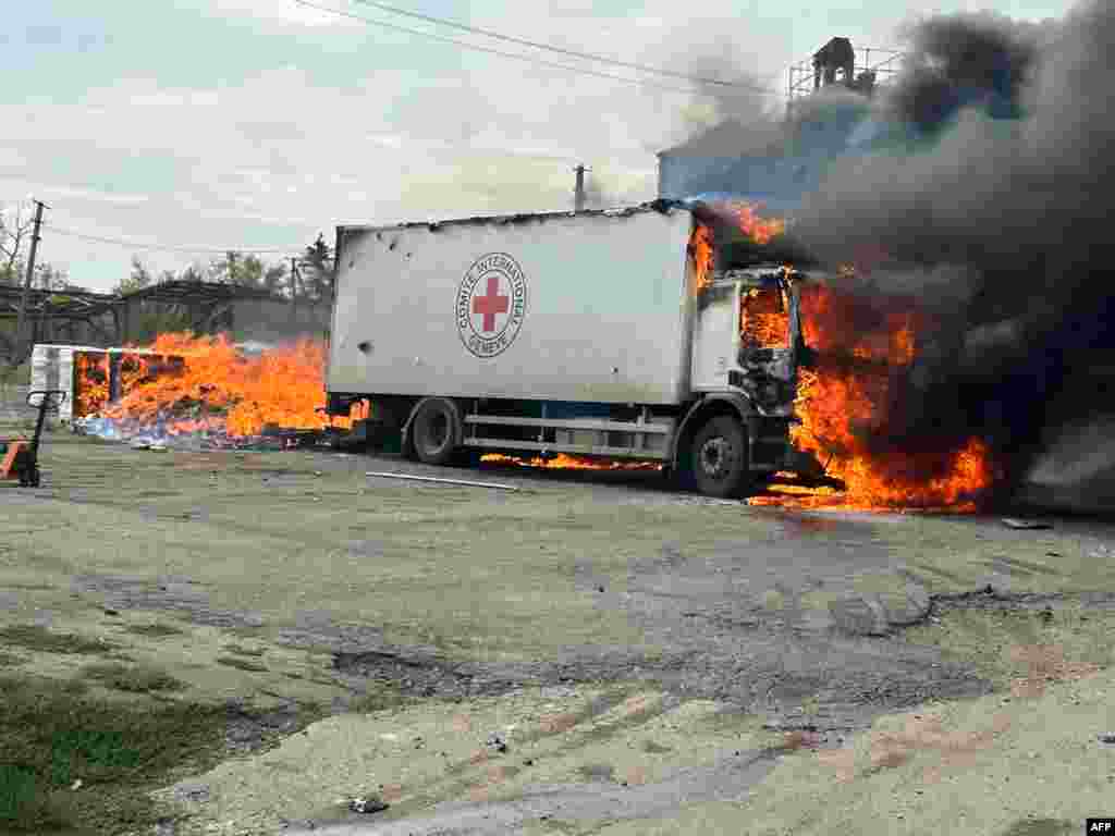 This handout photograph taken and released by the National Police of Ukraine shows a burning trucks of the International Committee of the Red Cross following an artillery shelling in the Donetsk region.