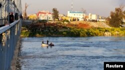 Iraqi rescuers search for survivors at the site where an overloaded ferry sank in the Tigris river near Mosul, Iraq, March, 21, 2019.