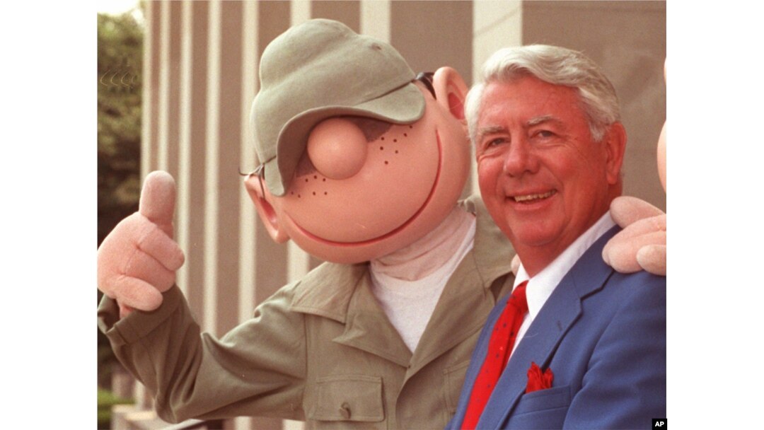 FILE - Mort Walker, who created the comic strip "Beetle Bailey" in 1950, poses with an actor in "Beetle" costume at the Pentagon in Washington, June 15, 1990.
