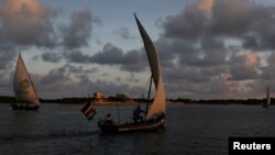 FILE - Traditional dhows sail by close to the island of Lamu, Kenya, Nov. 8, 2017. Lamu, a United Nations World Heritage Site, is also the site of a planned, controversial coal-fired power plant.