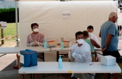 Health-care workers prepare to test people with COVID-19 symptoms near the beach in Saint Jean de Luz, southwestern France, Monday, July 27, 2020.