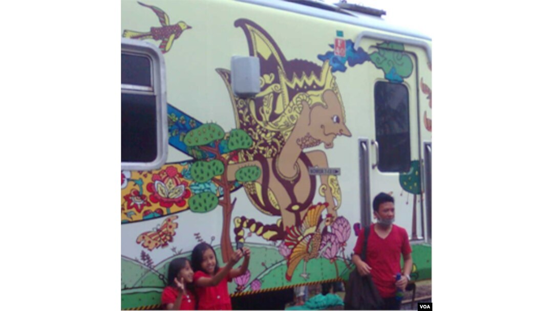 Masyarakat berfoto-foto di hadapan gerbong kereta api batik Argo Parahyangan.