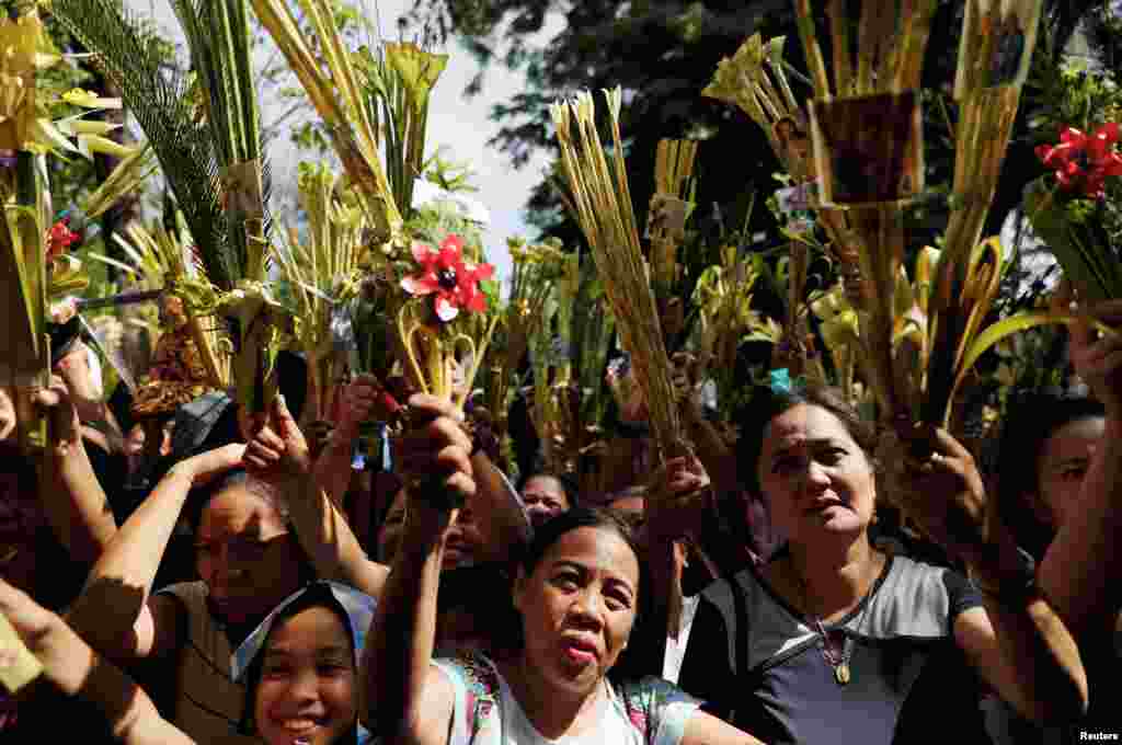 Filipino Catholics wave palm fronds to be blessed before Palm Sunday mass in a Catholic church in Paranaque City, Philippines.