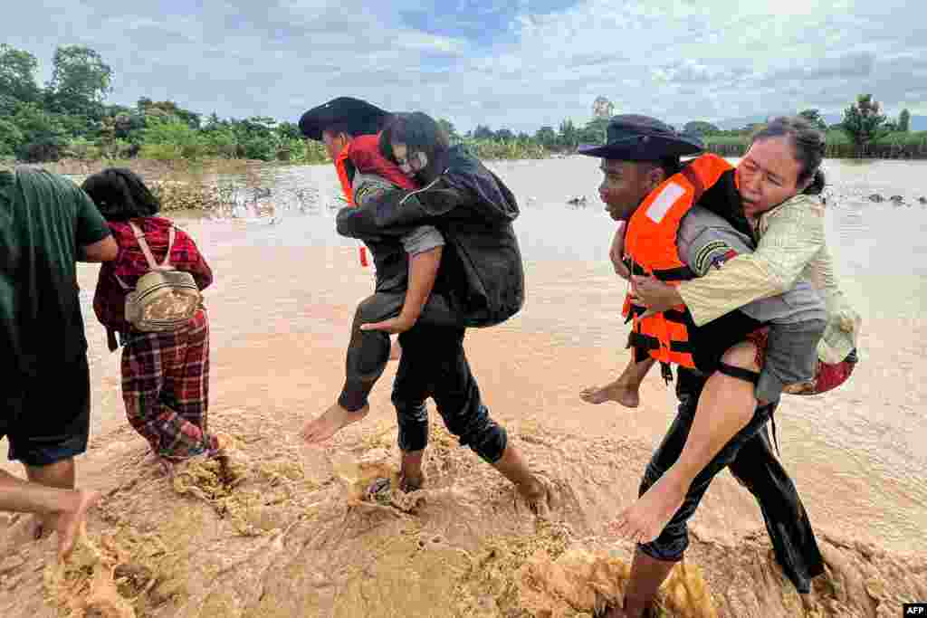 Polisi mengevakuasi warga melewati banjir di kota Pyinmana, yang terletak di wilayah Naypyidaw, Myanmar, menyusul hujan lebat yang dipicu oleh Topan Yagi. (AFP)