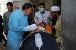 FILE - A man receives treatment at a hospital after an explosion in Kabul, Afghanistan, Aug. 7, 2019. A suicide car bomber targeted the police headquarters in a minority Shiite neighborhood in western Kabul. The Taliban claimed responsibility.