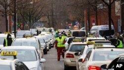 People arrive and depart with taxies at the COVID-19 vaccination center in the district Treptow in Berlin, Germany, Jan. 28, 2021. 