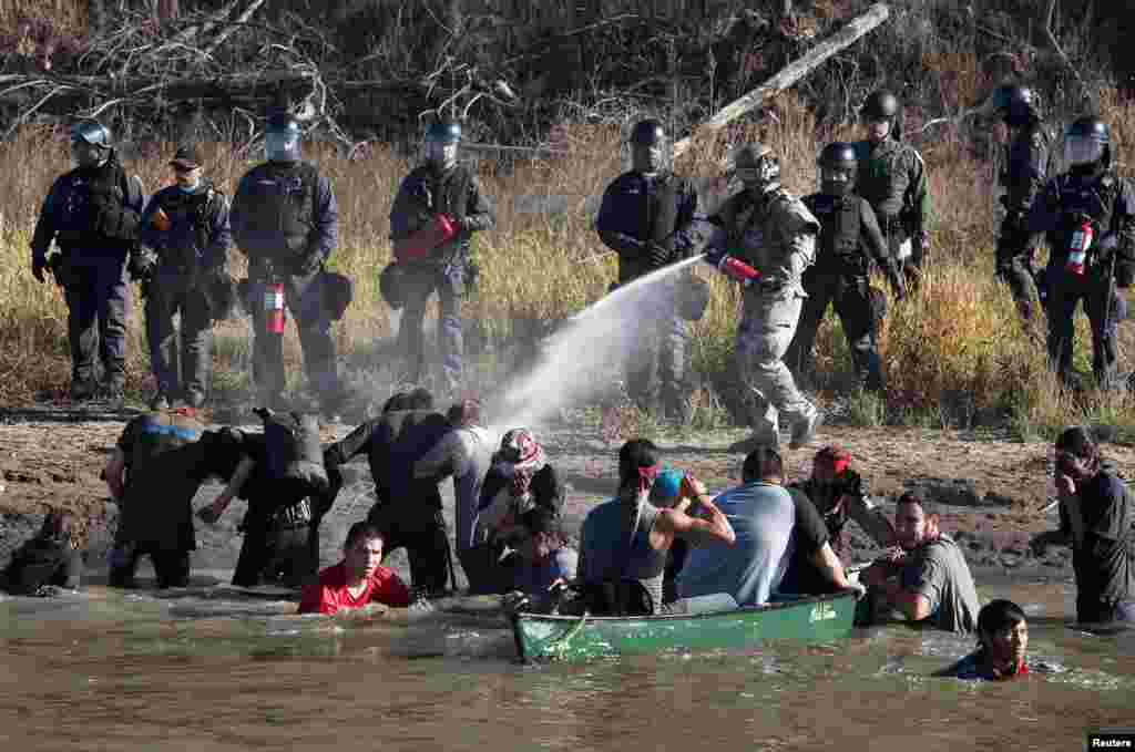 Police use pepper spray against protesters trying to cross a stream near an oil pipeline construction site near Standing Rock Indian Reservation, north of Cannon Ball, North Dakota, Nov. 2, 2016.