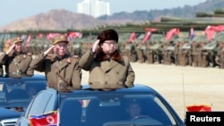 North Korean leader Kim Jong Un salutes as he arrives to inspect a military drill at an unknown location.