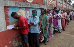 People line up to get inoculated against COVID-19 outside a vaccination center in Mumbai, India, Aug. 12, 2021.