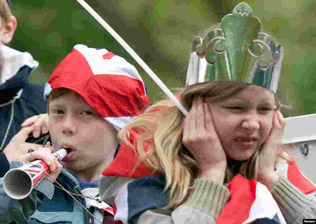 A boy blows a horn as crowds gathered along The Mall in St James Park, London June 5, 2012.