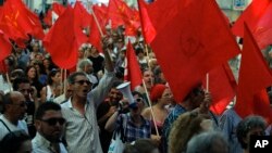 People shout slogans during a protest by the Portuguese Communist party, demanding the breakup of the Portuguese parliament and early elections, in Lisbon, July 3, 2013.