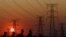 FILE: Locals walk past electricity pylons during frequent power outages from South African utility Eskom, caused by its aging coal-fired plants, in Orlando, Soweto, South Africa, September 28, 2022.