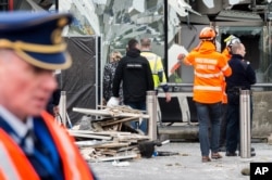 Police and other emergency workers stand in front of the damaged Zaventem Airport terminal in Brussels on March 23, 2016.