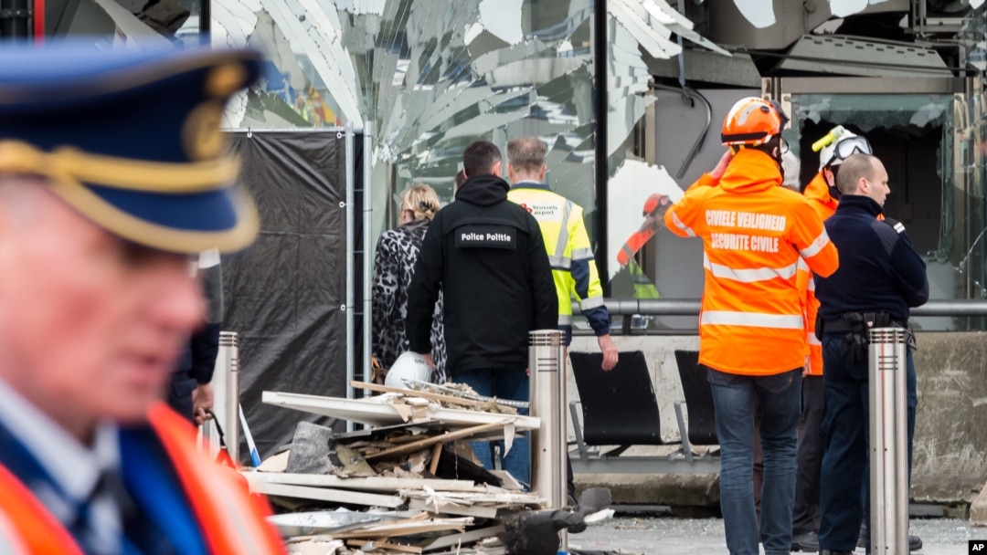 Police and other emergency workers stand in front of the damaged Zaventem Airport terminal in Brussels on March 23, 2016. 