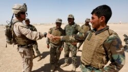 FILE - A U.S. Marine (L) shakes hands with an Afghan National Army soldier, during a training exercise in Helmand province, Afghanistan, July 5, 2017.