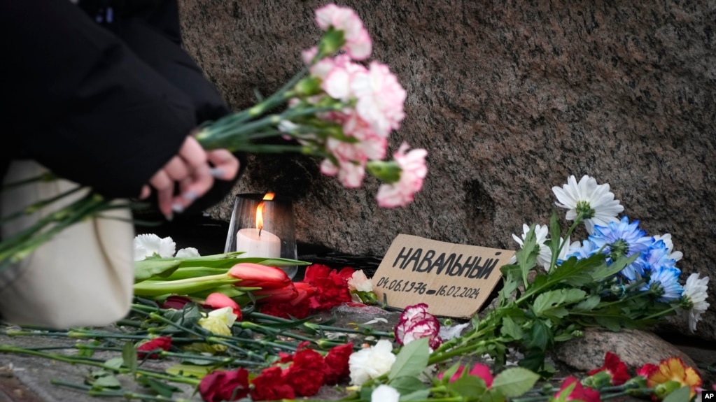 一名妇女在俄罗斯圣彼得堡的一处纪念碑前向阿列克谢·纳瓦尔尼献花致敬。(2024年2月21日)