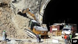 Rescuers work heavy machinery on Nov. 18, 2023, at the entrance to the site of an under-construction road tunnel that collapsed in mountainous Uttarakhand state, India, on Nov. 12, trapping 41 people.