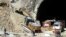 Rescuers work heavy machinery on Nov. 18, 2023, at the entrance to the site of an under-construction road tunnel that collapsed in mountainous Uttarakhand state, India, on Nov. 12, trapping 41 people.