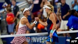 Lesia Tsurenko dari Ukrainia (kiri) bersalaman dengan Caroline Wozniacki dari Denmark setelah mengalahkan Wozniacki di nomor tunggal putri AS Terbuka di New York, 30 Agustus 2018.