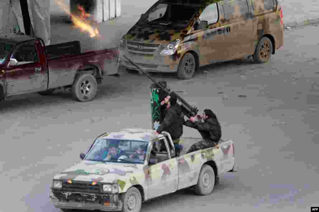 Syrian opposition fighters fire at planes of government forces flying overhead in the northern city of Aleppo. 