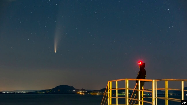 The Comet Neowise or C/2020 F3 is seen before sunrise over Balatonmariafurdo, Hungary, Tuesday, July 14, 2020. It passed closest to the Sun on July 3 and its closest approach to Earth will occur on July 23. (Gyorgy Varga/MTI via AP)