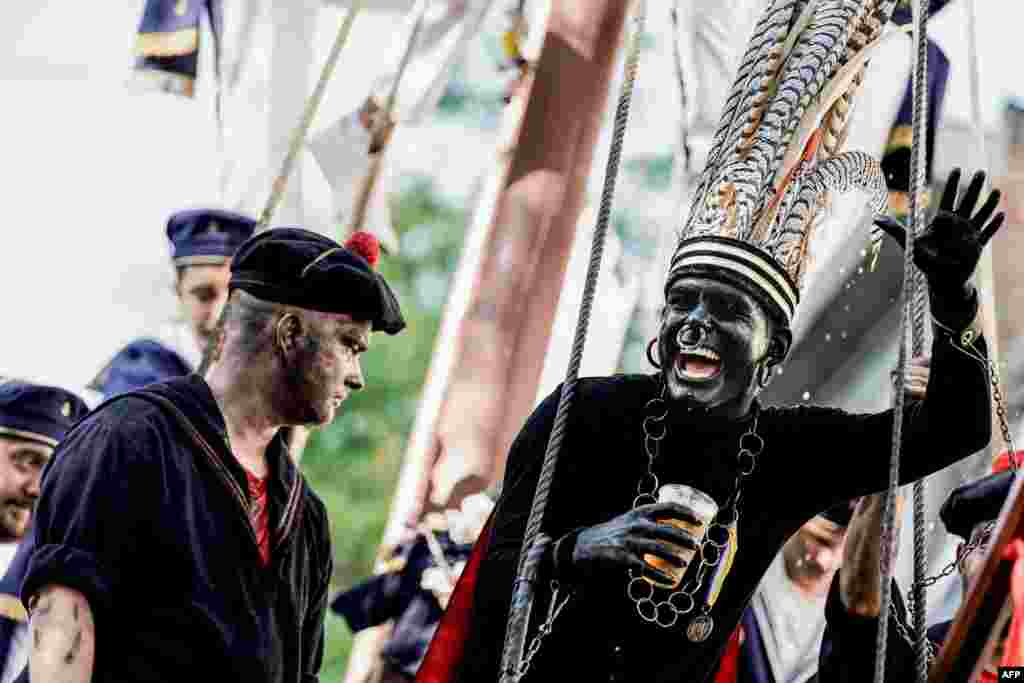 A man wearing a controversial makeup coloring blackface and called &quot;the savage&quot; gestures during a folk parade &quot;Ducasse&quot; of Ath in Ath, Belgium.